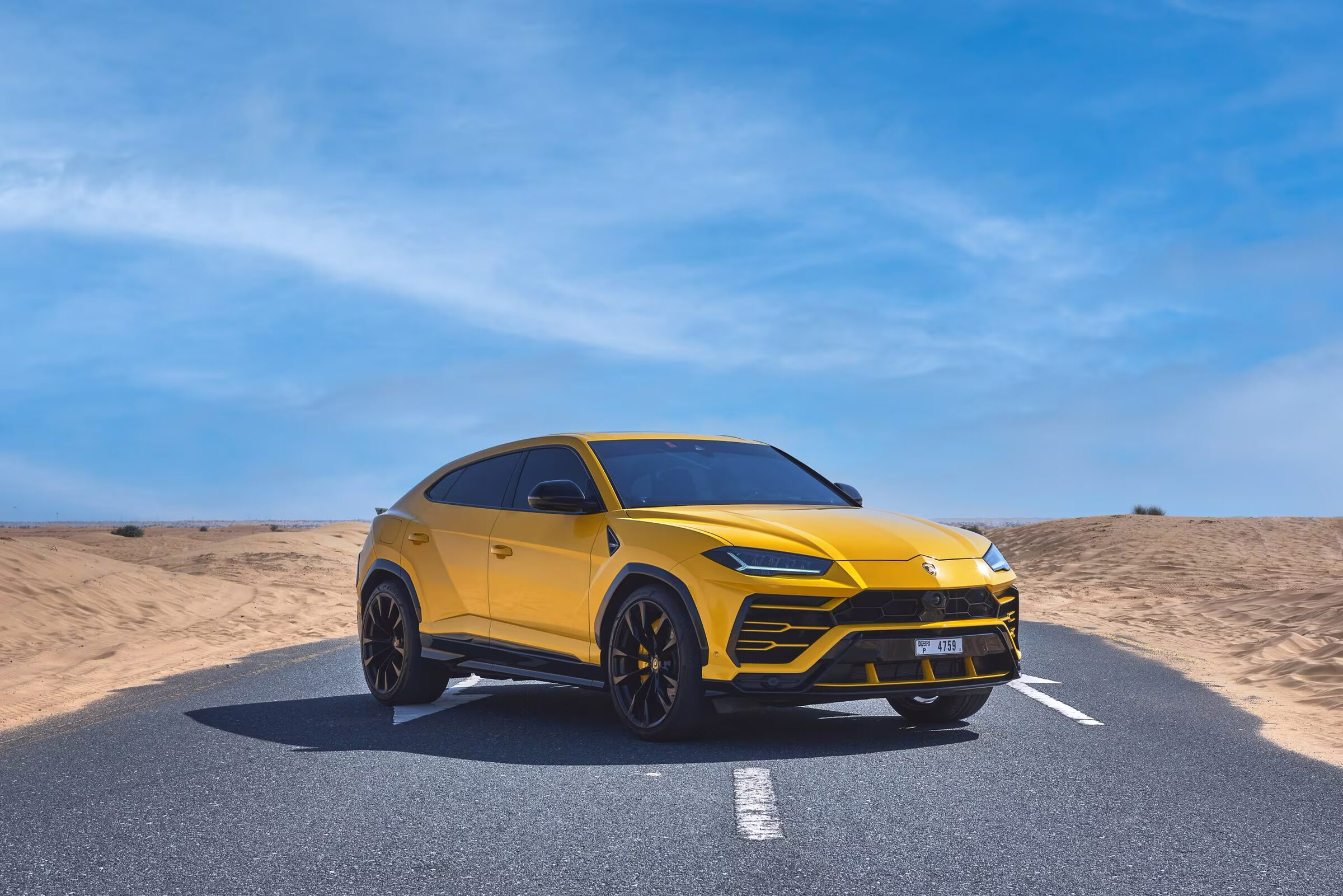 Yellow Lamborghini Urus on a desert road